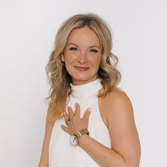 Korinna Söhnholz im weißen Kleid, die Hand auf dem Herzen