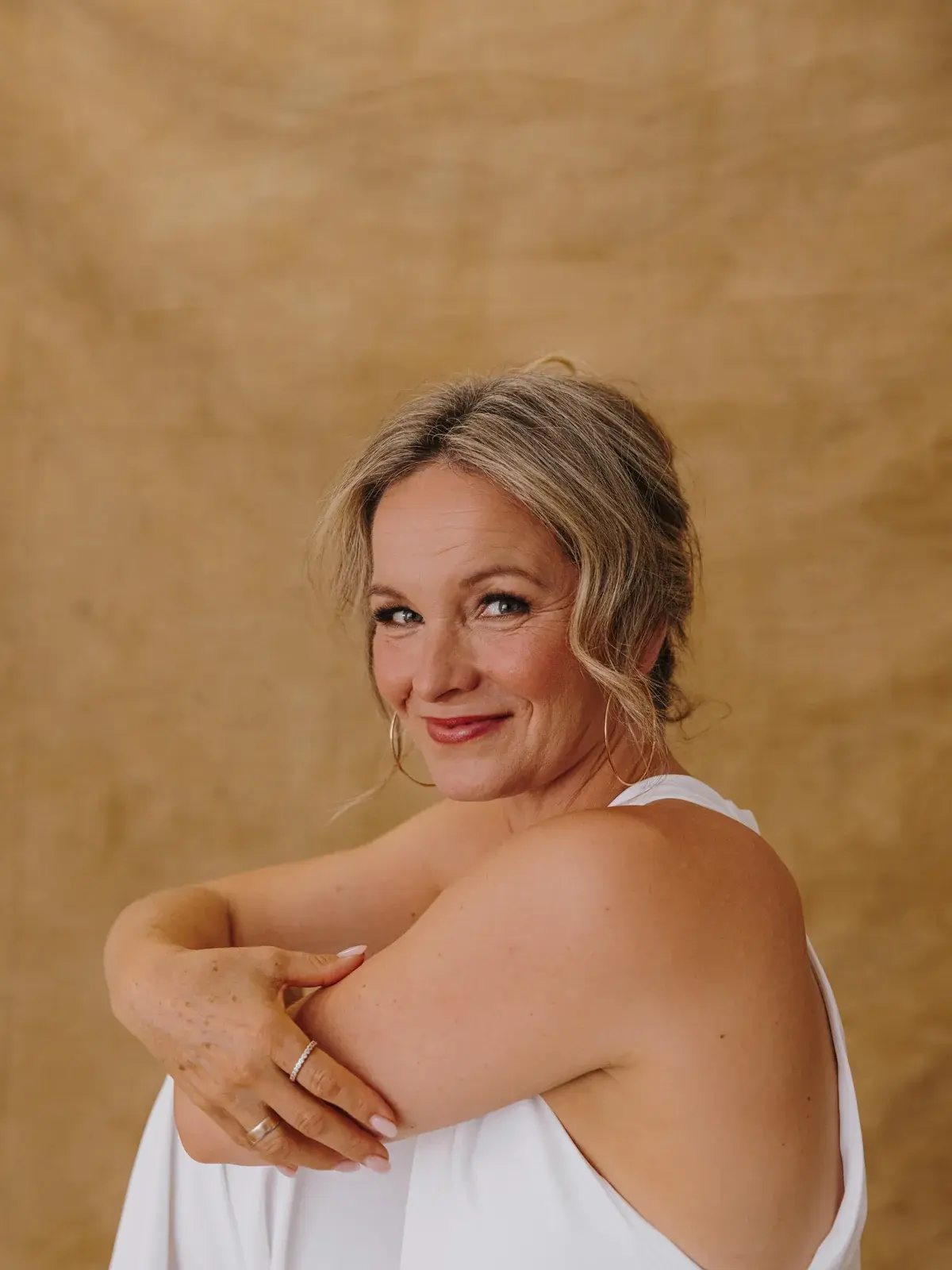 Korinna Söhnholz im weißen Kleid, den Blick über die Schulter