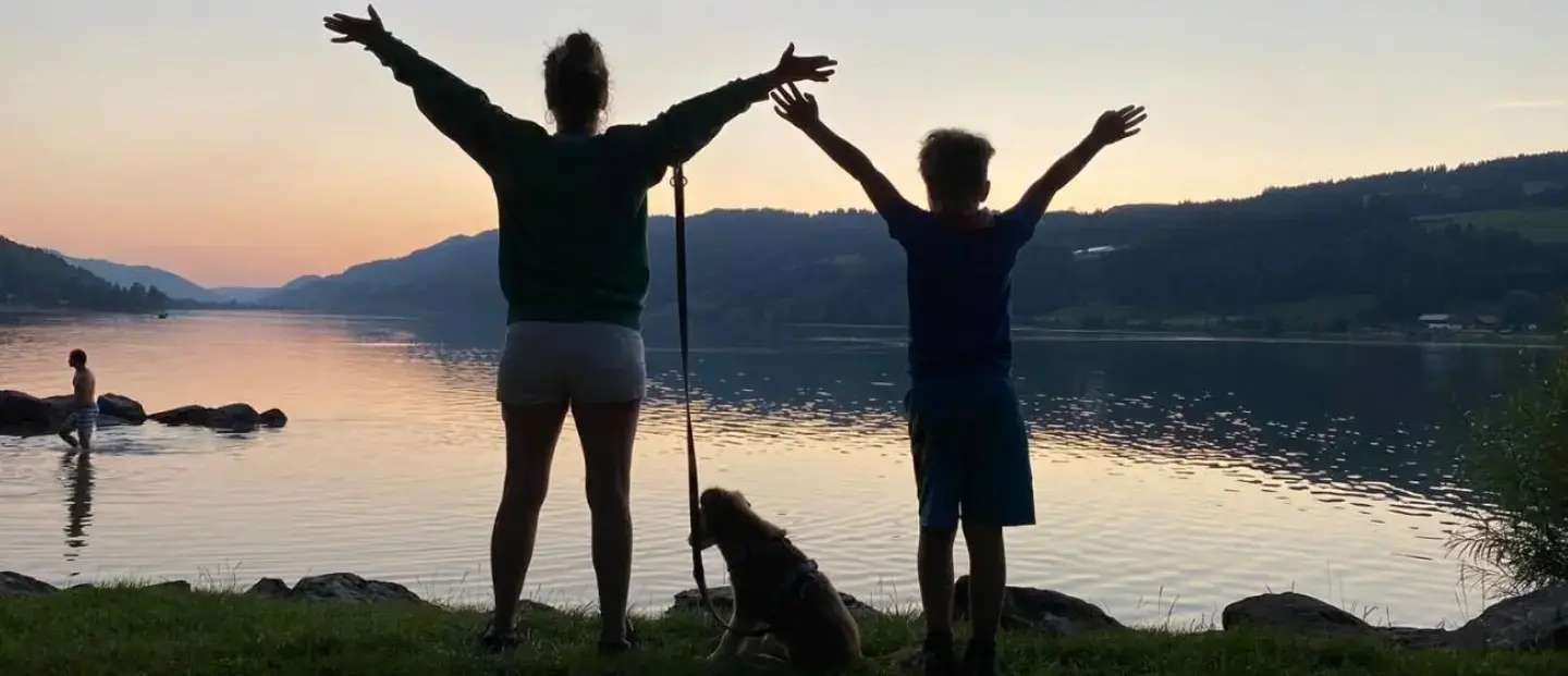 Korinna mit Max und dem Hund am See im Sonnenuntergang